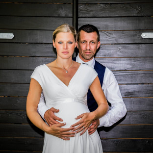 Schwangere Braut mit Ehemann bei Hochzeit