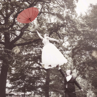 Braut fliegt mit Schirm, Levitationshooting, Hochzeitsfoto Wulfsmühle Tangstedt